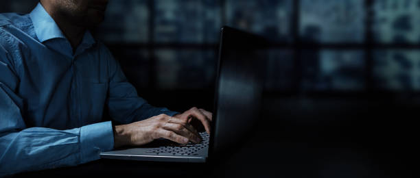 夜に暗いオフィスでラップトップに取り組んでいるビジネスマン。バナーコピースペース - contemporary laptop human hand computer keyboard ストックフォトと画像