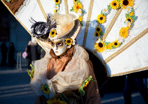 Masquerade. Beautiful mask in a carnival parade with people blurred in background.