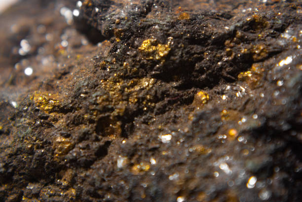 nahaufnahme von pyrit auf schwarzem glimmerschiefer - gold edelmetall stock-fotos und bilder