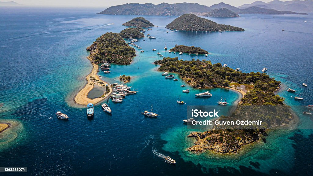 aerial view of islands and boats, people swimming on island and turquoise water, boats docked around the island, vacation location, famous place for vacation, wonderful islands Aerial view of islands and boats. Yassıca Island-Turkey Fethiye Stock Photo