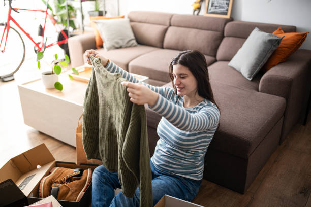 istock Young woman unwrapping package at home. 1363283859