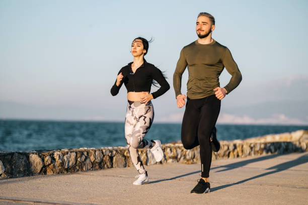 istock Young Couple Jogging At The Seaside In Summer 1363284004