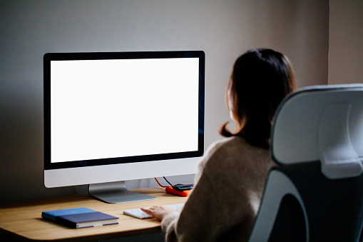 Mujer trabajando en casa con una pc de pantalla en blanco photo