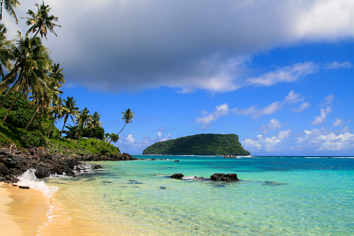 Playa tropical paradisíaca en el Océano Pacífico con agua turquesa, arena dorada y palmeras exóticas. Escapada de vacaciones idílica, vista desde la playa de Lalomanu en Upolu hasta la isla Nu