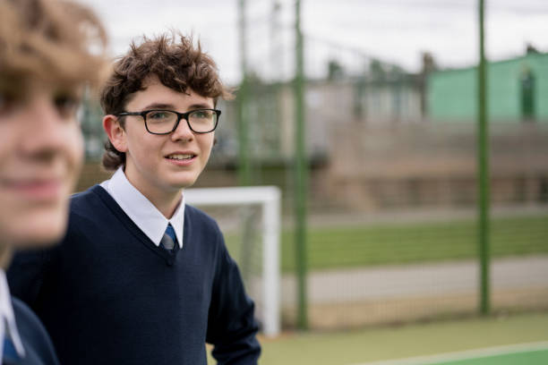 istock Secondary schoolboys standing outdoors on sports field 1363289828