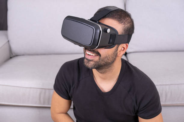 istock Young man in VR glasses headset at home interacting with virtual reality, smiling. close up. future technology, education video gaming 1363292590