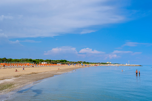 People relaxing on the beach of Cavallino-Treporti, part of the municipality of Venice and one of the destinations of summer tourism on the Adriatic riviera of Veneto.