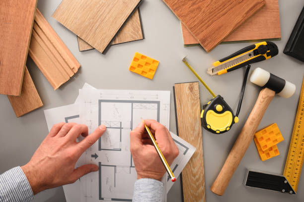 Hands in office developing interior project with wood top view Hands on designer on desk writing on blueprints developing interior project with wood samples and tools. Top view. building floor plan stock pictures, royalty-free photos & images