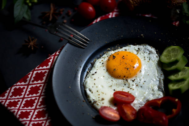 Breakfast set for christmas. Pan of fried eggs. Cucumber and cherry-tomatoes with Turkish bagels on dark table surface, top view. Christmas Breakfast.