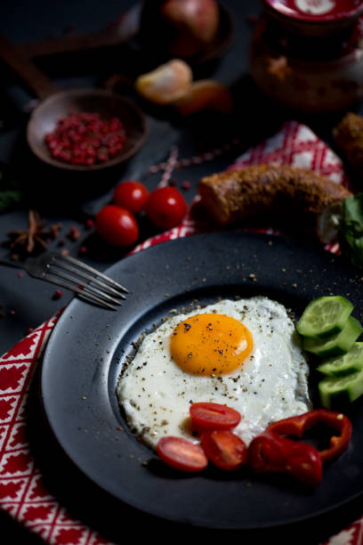 istock Breakfast set for christmas. Pan of fried eggs. Cucumber and cherry-tomatoes with Turkish bagels on dark table surface, top view. Christmas Breakfast. 1363300637