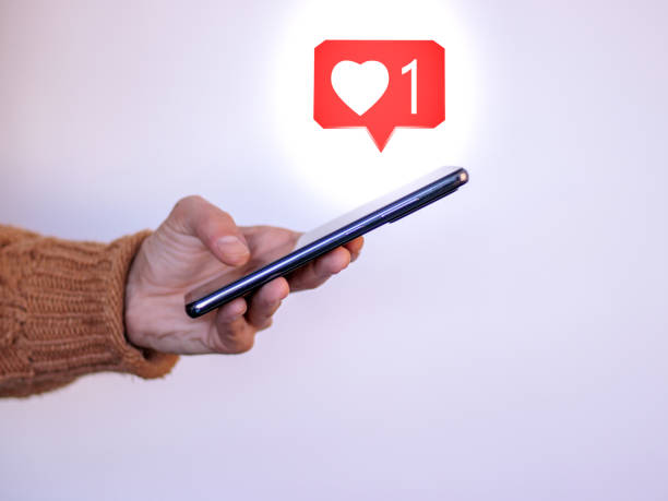 istock Girl's hand with mobile observing how many likes she has on Instagram 1363301223