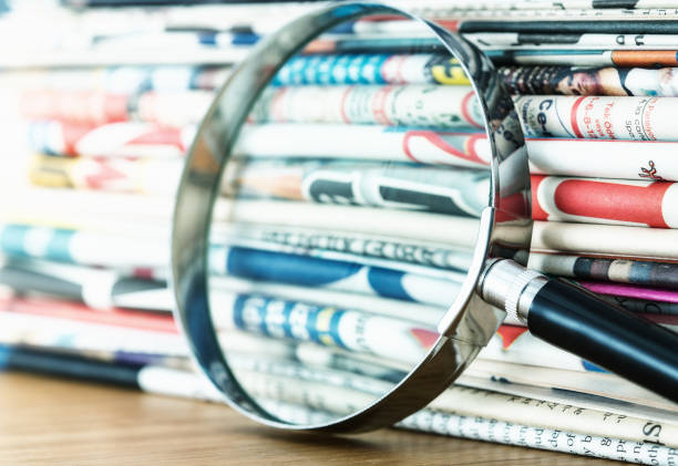 istock Stack of newspapers and magnifying glass 1363302089
