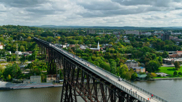 Tourists on Walkway Over the Hudson in Poughkeepsie, NY Drone shot of Walkway Over the Hudson, a former railway bridge converted into a pedestrian walkway across the Hudson River between Poughkeepsie and Highland in New York State. elevated walkway stock pictures, royalty-free photos & images