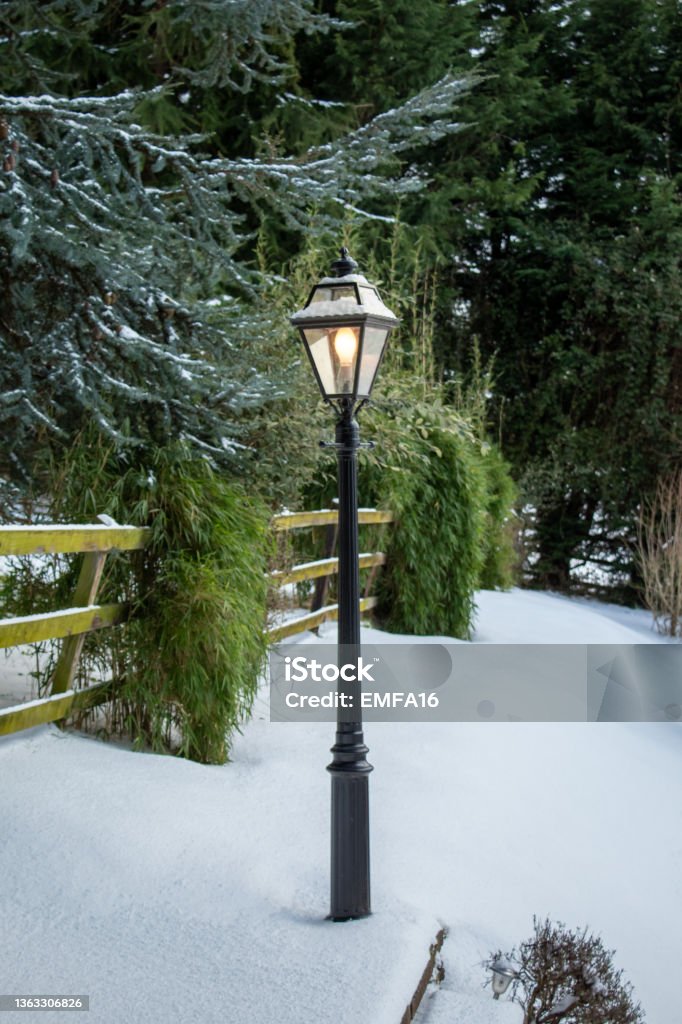 Light on in Narnia Lamp Post in a Snowy Garden, Ireland Light on in Lamp Post in a Snowy Garden, Ireland Cold Temperature Stock Photo