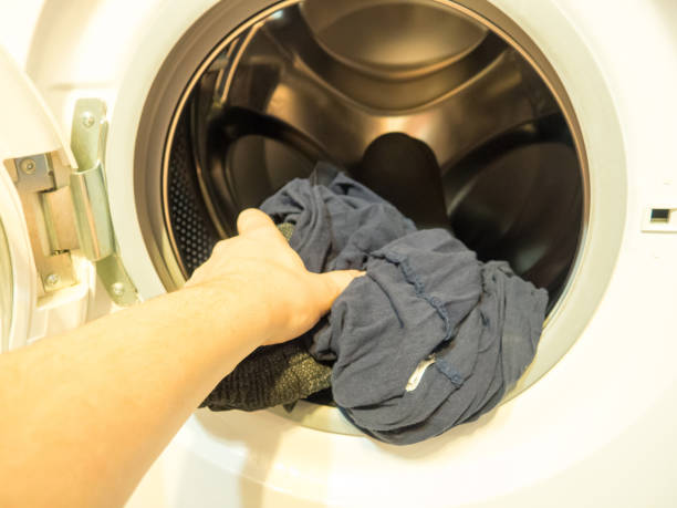 istock man puts clothes in the washing machine, close-up 1363307491