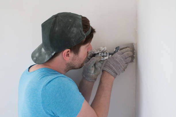 istock Senior man with putty knife plastering repairing wall 1363307534