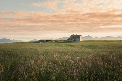 A abandoned farm by the coastline on Andøya. The sun is setting.