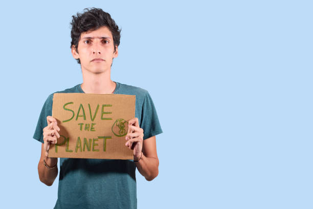 istock Young guy with cardboard sign with message to save the planet, isolated with copy space. 1363309481