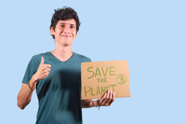 istock Young guy with cardboard sign with message to save the planet, isolated with copy space. 1363309493