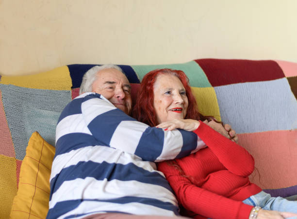 istock Caring elderly couple cuddling on the sofa at home. 1363309630