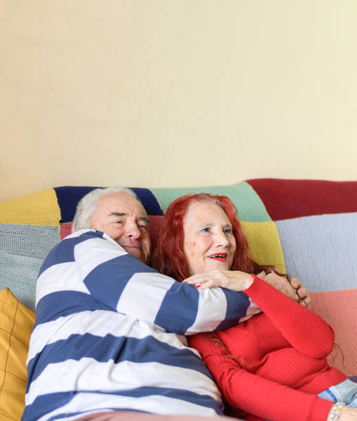 istock Affectionate elderly couple cuddling on the sofa at home. Concept of love and unity 1363310149