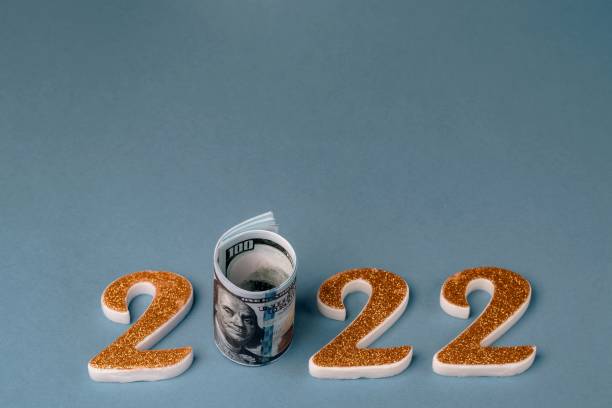 istock Number 2022 with a roll of one hundred dollar bills on a blue background. 1363316996