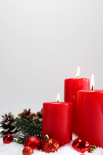 Red Christmas candles decorated with fir branches and ornaments. Christmas card. Copy space.