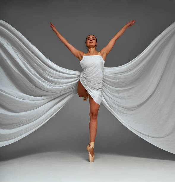 Ballerina Dancing with Silk Fabric, Modern Ballet Dancer in Fluttering Waving Cloth, Pointe Shoes, Gray Background.