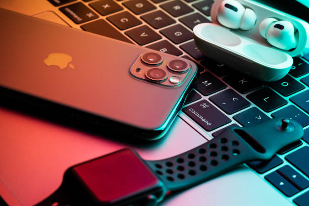 iphone 11 pro com airpods pro e apple watch com um macbook em segundo plano. - apple computers audio - fotografias e filmes do acervo