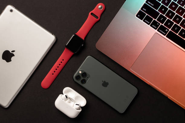 flat lay of different apple products on a grey background. - apple macintosh laptop apple computers computer imagens e fotografias de stock