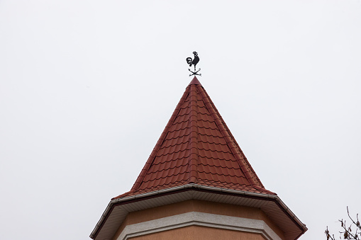 The roof of the house is made of red metal tiles, a beautiful large chimney.