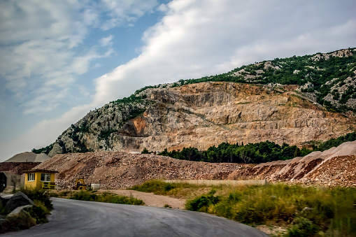 View from the window of a passing car on a stone quarry in Albania. View from the road to the cliff