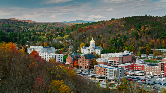 Aerial shot of the state capitol building in Montpelier, Vermont in Fall, flying over downtown buildings with a mountainside covered in colorful autumnal trees behind. 

Authorization was obtained from the FAA for this operation in restricted airspace.