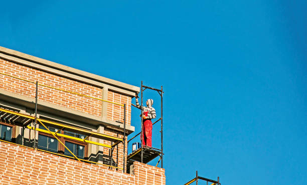 High-rise finishing works. An employee repairs the facade of a building. stock photo