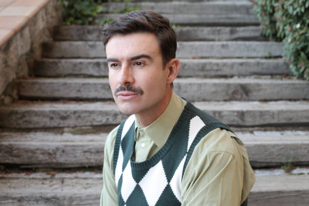 istock Man with a mustache wearing sleeveless rhombus sweater 1363334816