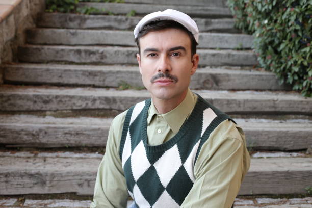 man with a mustache wearing sleeveless rhombus sweater - clothes iron 1970s imagens e fotografias de stock