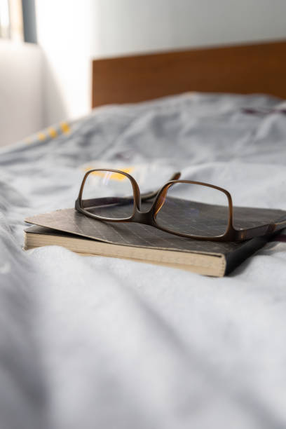 istock glasses on a closed notebook on a bed with light blue background, lifestyle and intellectual pastimes, reading 1363336201