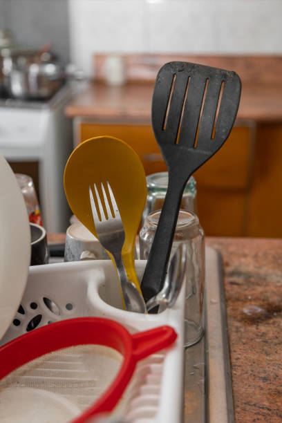 istock kitchen with several dishes recently washed in the sink drying, lifestyle with dishes, household objects such as spoon, fork, plates 1363336229