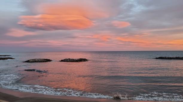 istock Sea sunset with waves and rocks and clouds 1363336840