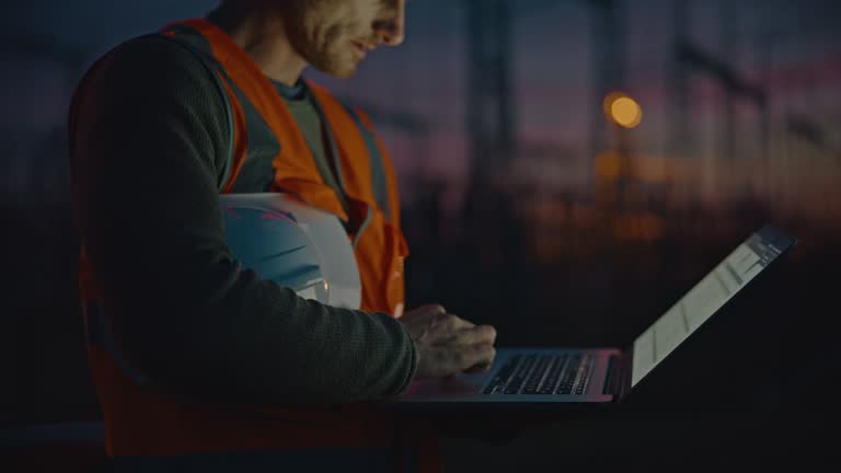 Dedicated engineer working on sunset using laptop