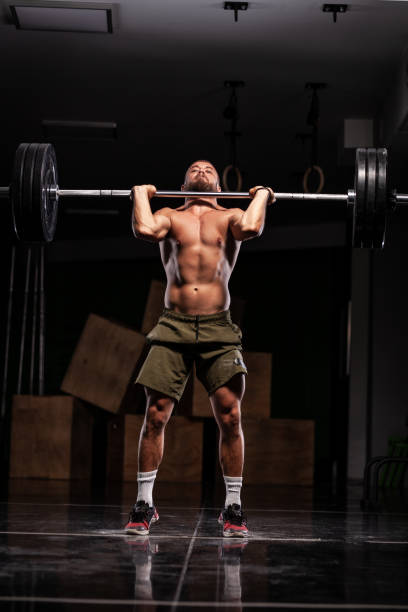 istock Muscular athlete lifting very heavy barbell 1363339056