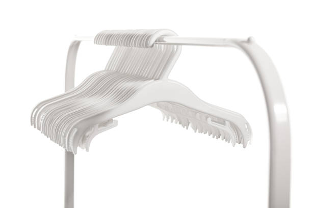 White plastic hangers for clothes hanging on rod from clothing rack. Isolated on white background.. White plastic hangers for clothes hanging on rod from clothing rack. Isolated on white background. clothes hanger rod stock pictures, royalty-free photos & images