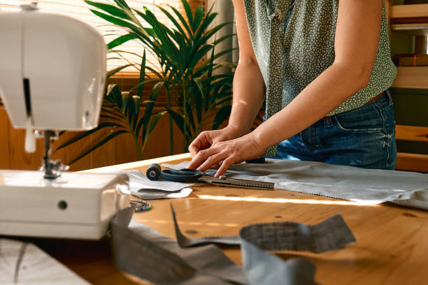 istock Woman is sketching pattern on a linen fabric Seamstress basting and sewing in a small studio Sartorial clothes Fashion studio, tailoring, handmade clothing concept Slow fashion Conscious consumption 1363339168