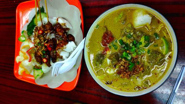 istock Typical Indonesian Goat Curry Menu with yellow sauce and chicken satay rice cake 1363348659