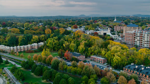 Townhouses in Old North End, Burlington, VT - Aerial Aerial shot of Burlington, Vermont on a hazy evening in early Fall, looking towards a residential neighborhood shaded by trees that are beginning to to turn red, yellow and orange. The Green Mountains can be seen in the distance. 

Authorization was obtained from the FAA for this operation in restricted airspace. green mountains appalachians photos stock pictures, royalty-free photos & images