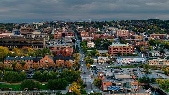 Aerial shot of Burlington, Vermont on a hazy evening in early Fall, looking along streets of historic buildings, shaded by trees that are beginning to to turn red, yellow and orange. The Green Mountains can be seen in the distance. 

Authorization was obtained from the FAA for this operation in restricted airspace.