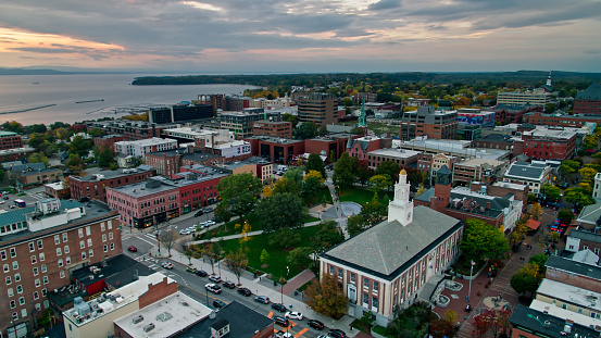 Drone shot of Burlington, Vermont on a colorful evening in Fall, looking down on City Hall and the park behind and Church Street Marketplace, with Lake Champlain in the distance.\n\nAuthorization was obtained from the FAA for this operation in restricted airspace.