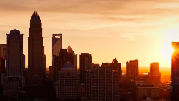 Drone shot of Charlotte, North Carolina at dusk, with the Uptown skyline silhouetted against a colorful sky and the setting sun. 

Authorization was obtained from the FAA for this operation in restricted airspace.