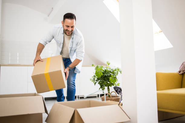 istock Young man bringing boxes with belongings into his new apartment 1363351879