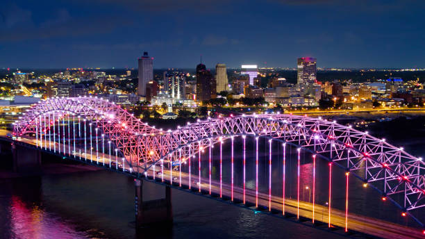 Pink and Purple Lights Shimmering on Hernando de Soto Bridge Over Mississippi River Aerial shot of the spectacular light show on the Hernando de Soto Bridge, which carries Interstate 40 across the Mississippi between Tennessee and Arkansas, with downtown Memphis in the background. memphis tennessee stock pictures, royalty-free photos & images